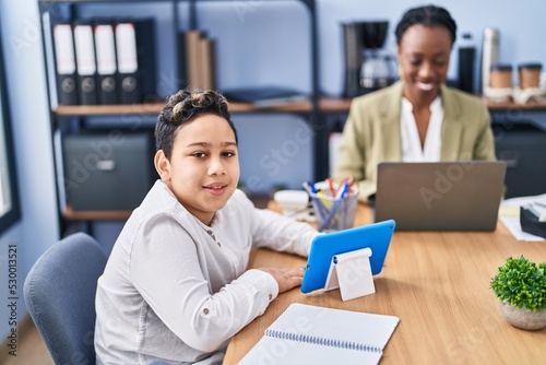 African american mother and son using laptop and touchpad working at office