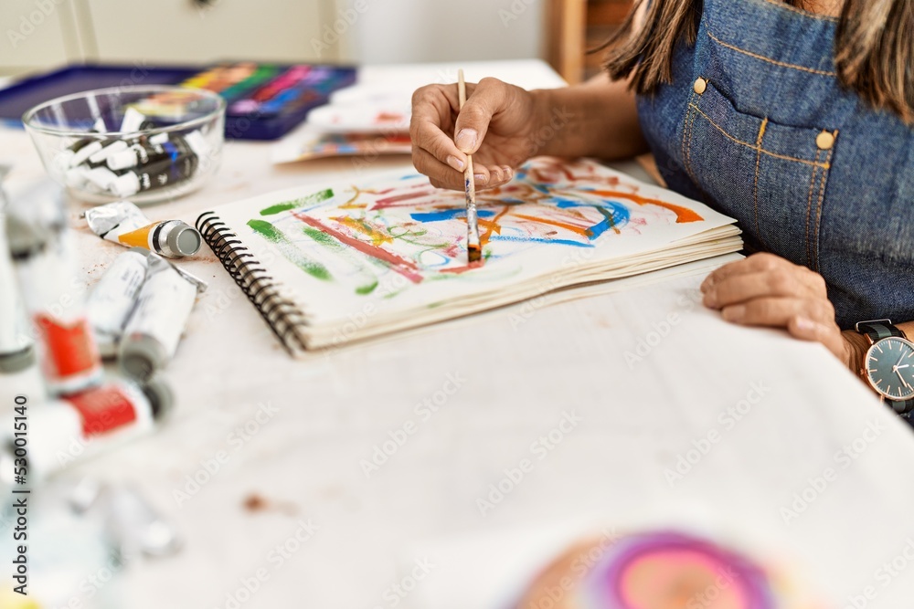 Fototapeta premium Young hispanic artist woman smiling happy drawing at art studio.
