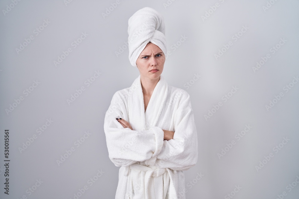 Blonde caucasian woman wearing bathrobe skeptic and nervous, disapproving expression on face with crossed arms. negative person. Blonde caucasian woman wearing bathrobe skeptic and nervous, disapproving expression on face with crossed arms. negative person.