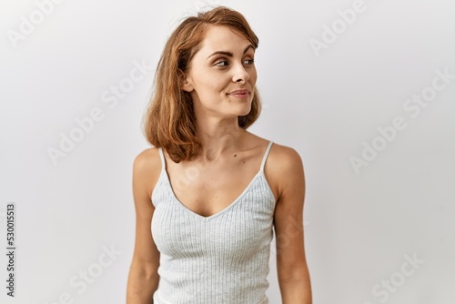 Beautiful caucasian woman standing over isolated background smiling looking to the side and staring away thinking.