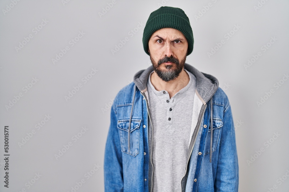 Young hispanic man with tattoos wearing wool cap skeptic and nervous, frowning upset because of problem. negative person. Young hispanic man with tattoos wearing wool cap skeptic and nervous, frowning upset because of problem. negative person.