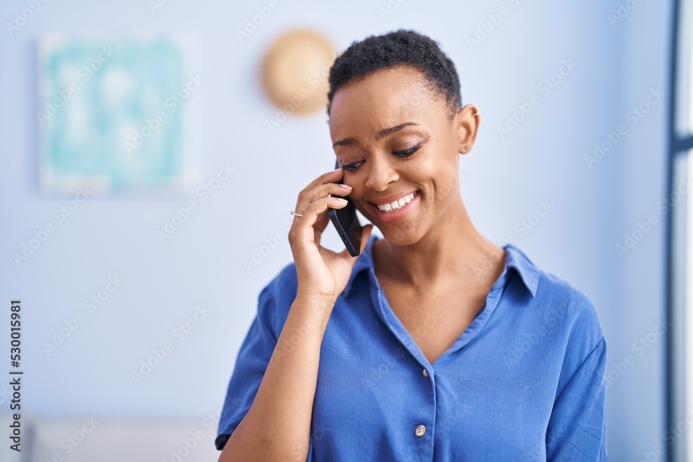 African american woman talking on smartphone standing at home African american woman talking on smartphone standing at home
