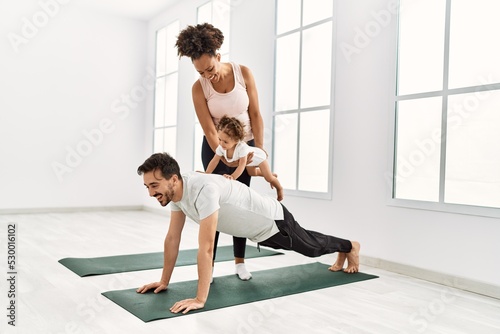 Couple and daughter smiling confident training at sport center
