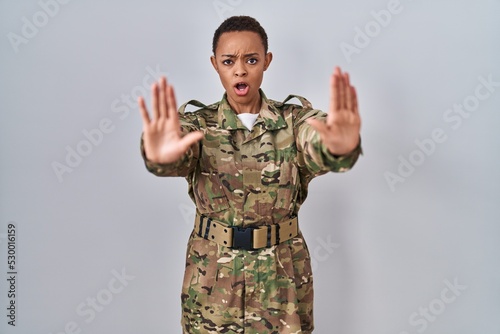 Beautiful african american woman wearing camouflage army uniform doing stop gesture with hands palms, angry and frustration expression