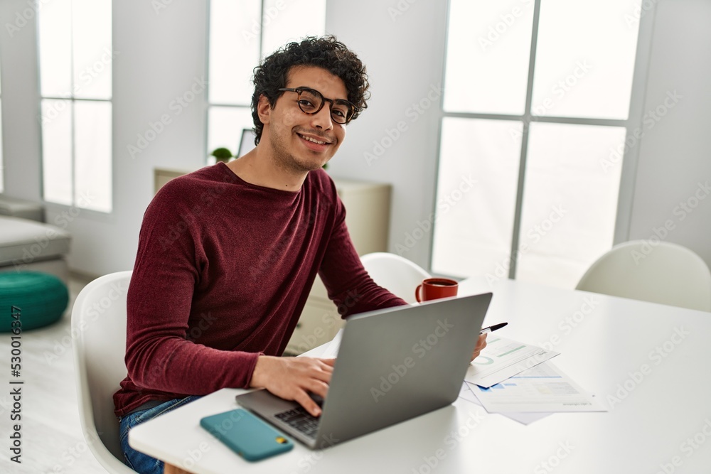 Young hispanic man using laptop working at home. Young hispanic man using laptop working at home.