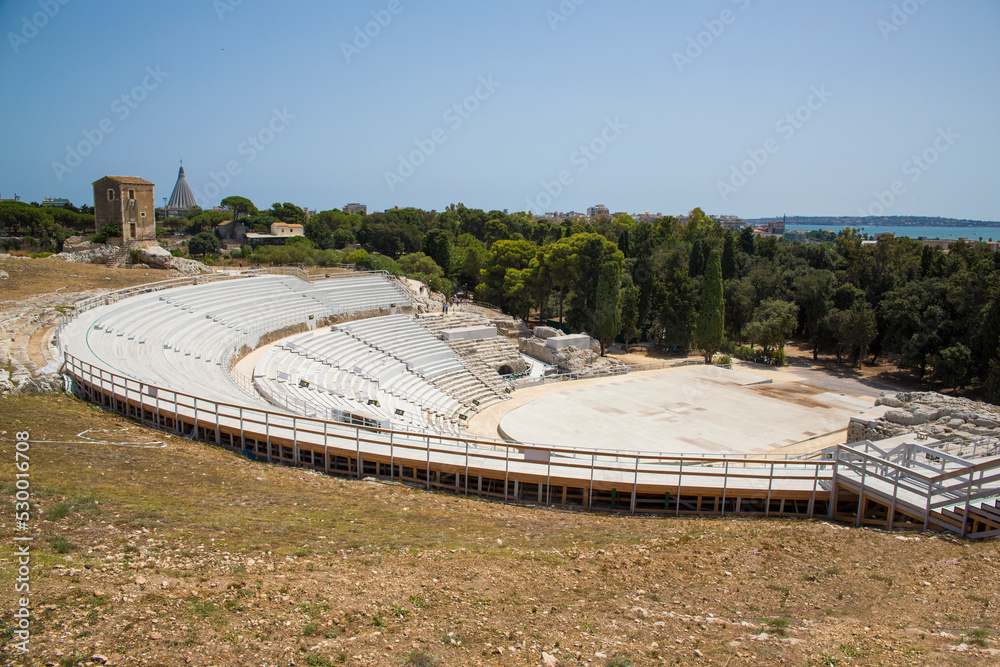 View of the Greek theater in Syracuse in Sicily, Italy. The site lies on the south slopes of the Temenite hill, overlooking the modern city. It is visited by millions of tourists every year.