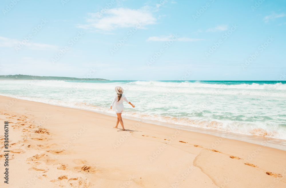 Woman walking along the beach on beautiful summer day in Australia Woman walking along the beach on beautiful summer day in Australia