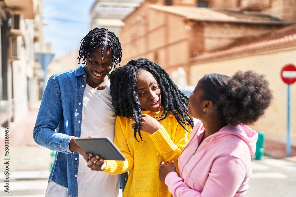 Fototapeta premium African american friends standing together watching video on touchpad at street