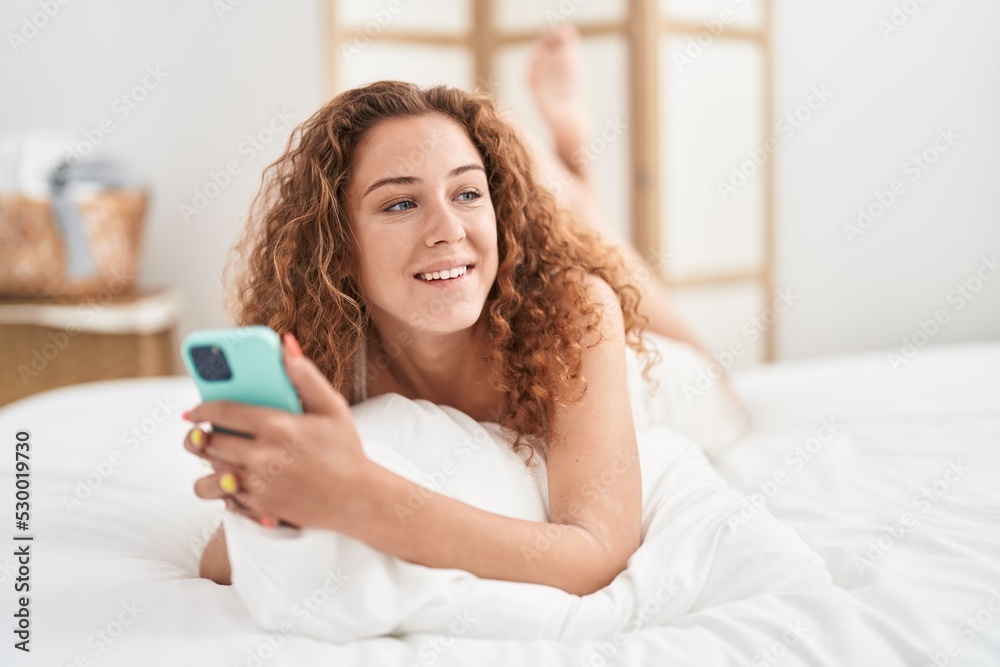 Young beautiful hispanic woman using smartphone lying on bed at bedroom Young beautiful hispanic woman using smartphone lying on bed at bedroom