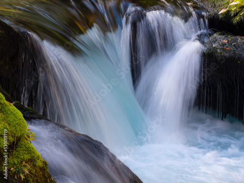 Fototapeta Naklejka Na Ścianę i Meble -  CLOSE UP: Wild mountain river flowing over mossy rocks forming small waterfalls
