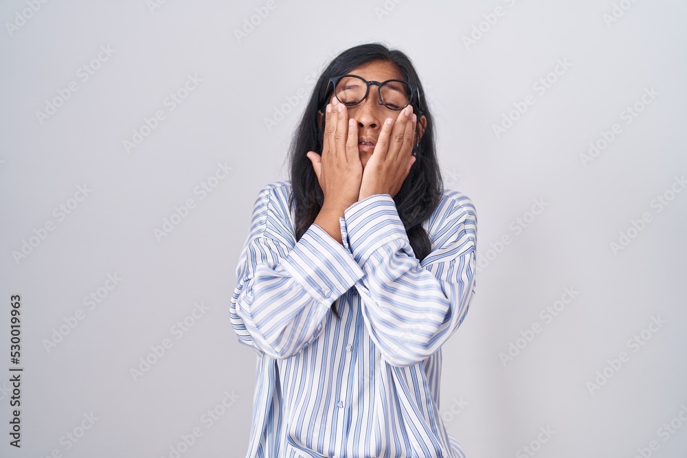 Young hispanic woman wearing glasses rubbing eyes for fatigue and headache, sleepy and tired expression. vision problem Young hispanic woman wearing glasses rubbing eyes for fatigue and headache, sleepy and tired expression. vision problem