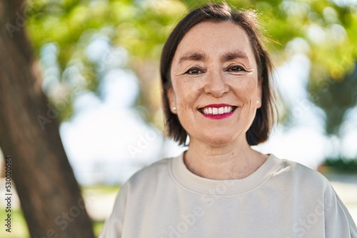 Middle age woman smiling confident standing at park