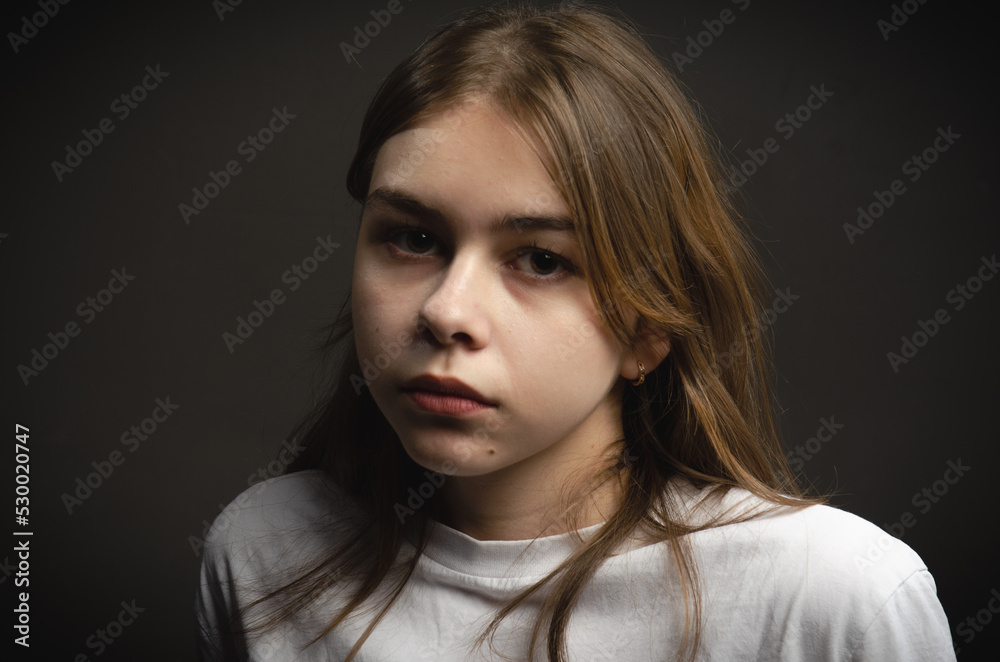 portrait of a girl in a white T-shirt on a dark background portrait of a girl in a white T-shirt on a dark background
