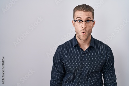 Young caucasian man standing over isolated background afraid and shocked with surprise expression, fear and excited face. © Krakenimages.com