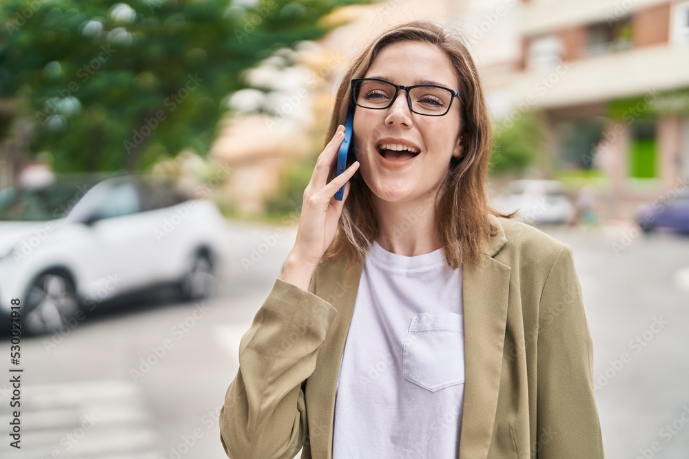 Young woman business worker talking on smartphone at street