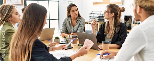 Quadro em tela Group of business workers concentrate speaking and working at the office