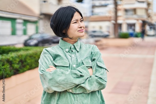 Young chinese woman smiling confident standing with arms crossed gesture at street © Krakenimages.com