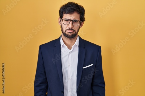 Handsome latin man standing over yellow background depressed and worry for distress, crying angry and afraid. sad expression.