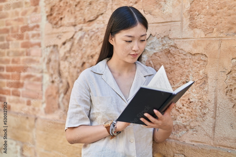 Chinese woman reading book at street Chinese woman reading book at street