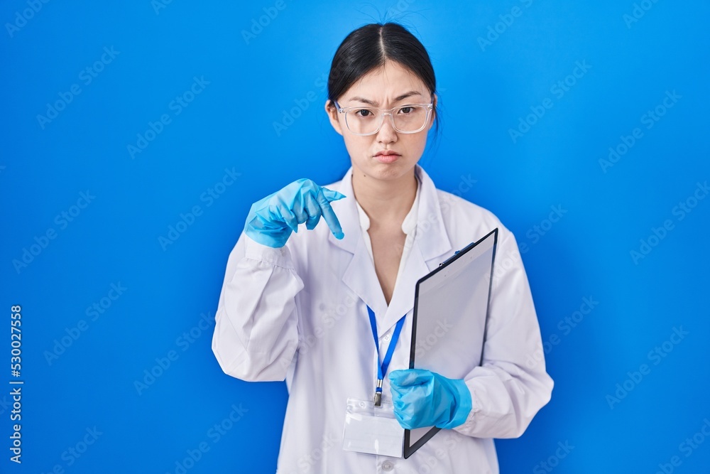 Chinese young woman working at scientist laboratory pointing down looking sad and upset, indicating direction with fingers, unhappy and depressed. Chinese young woman working at scientist laboratory pointing down looking sad and upset, indicating direction with fingers, unhappy and depressed.