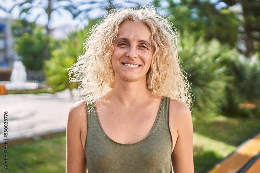 Middle age blonde woman smiling confident walking at park Middle age blonde woman smiling confident walking at park