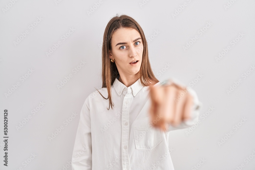 Young caucasian woman standing over isolated background pointing displeased and frustrated to the camera, angry and furious with you Young caucasian woman standing over isolated background pointing displeased and frustrated to the camera, angry and furious with you