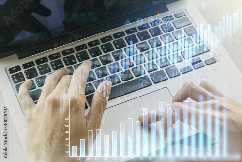 Double exposure of abstract creative financial diagram with hand typing on computer keyboard on background, banking and accounting concept photo