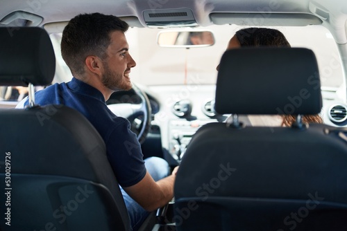 Young hispanic couple smiling confident driving car at street