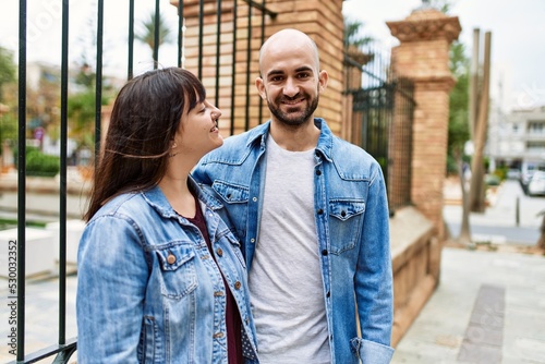 Young hispanic couple smiling happy standing at the city.