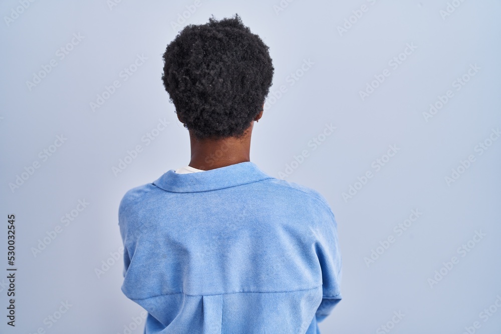 African american woman standing over blue background standing backwards looking away with crossed arms African american woman standing over blue background standing backwards looking away with crossed arms