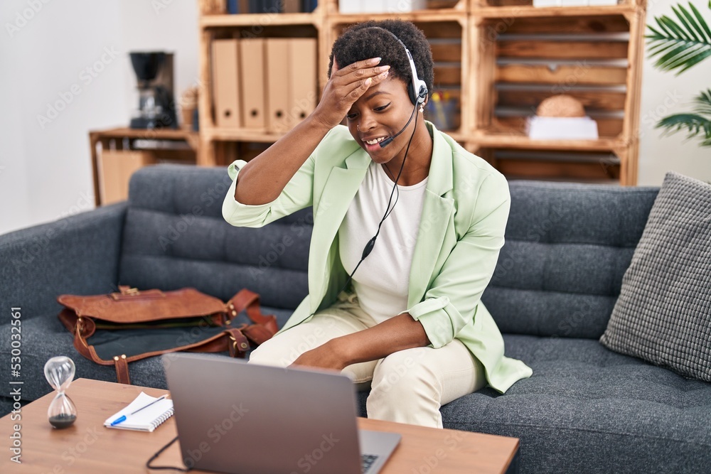 Fototapeta premium African american woman doing online session at consultation office stressed and frustrated with hand on head, surprised and angry face