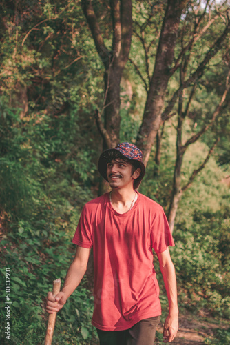 indian guy smiling during a hike in the forest trail