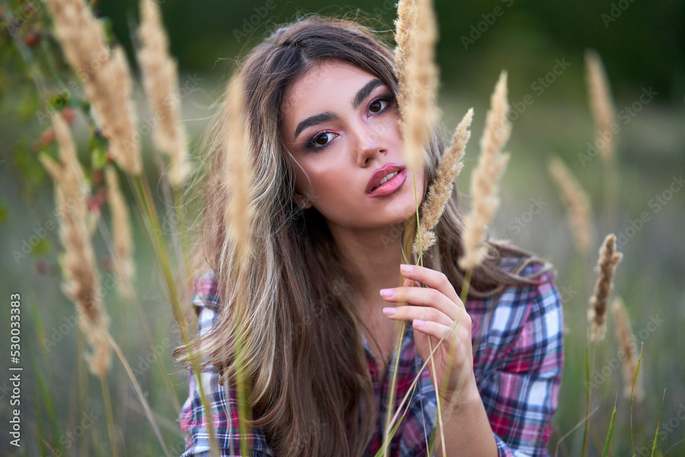 Naklejka premium Young woman in a grass field