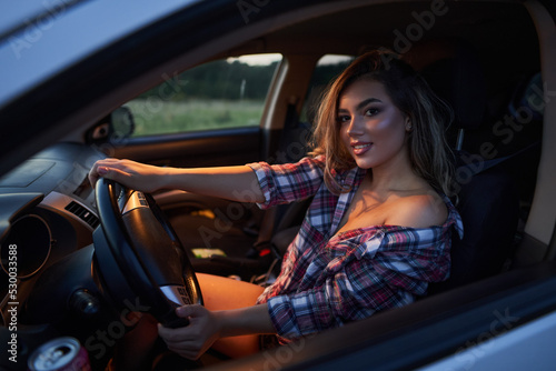 Fotografie Beautiful woman in the car at sunset