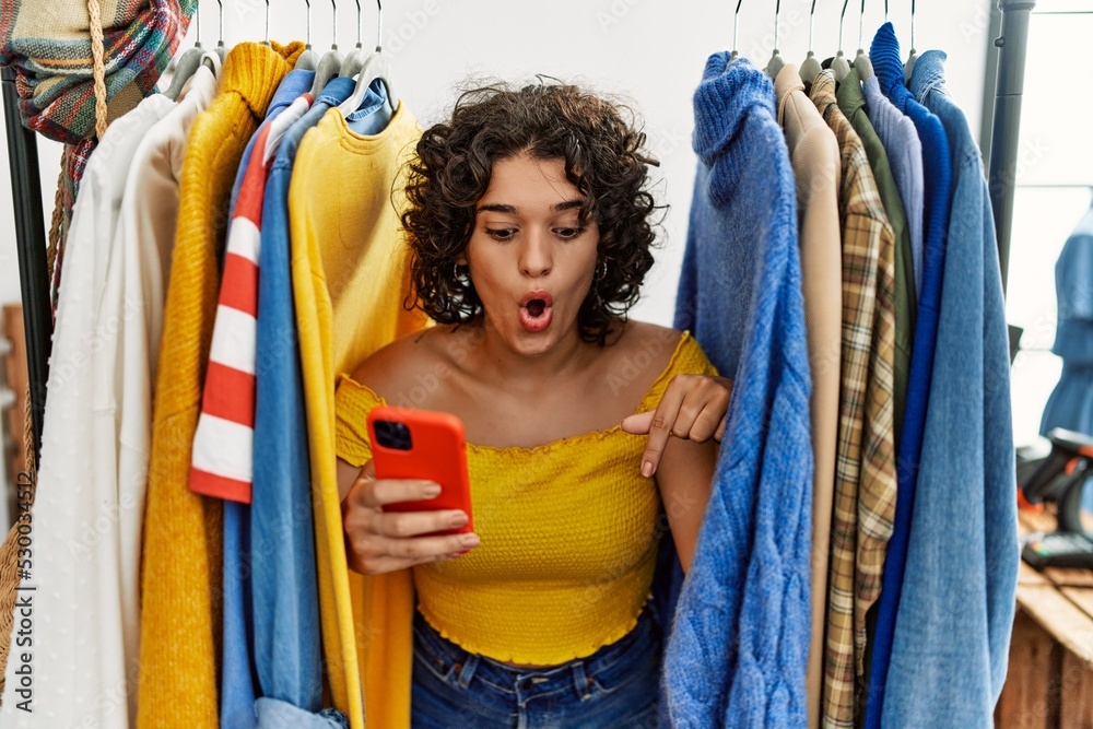 Hispanic Rack Young hispanic woman searching clothes on clothing rack using ...