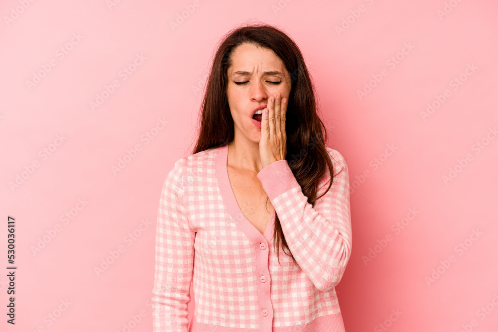 Young caucasian woman isolated on pink background yawning showing a tired gesture covering mouth with hand. Young caucasian woman isolated on pink background yawning showing a tired gesture covering mouth with hand.