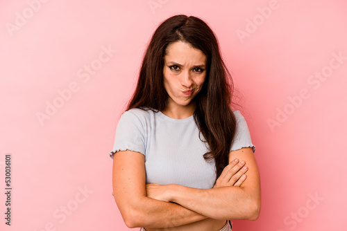 Canvas Print Young caucasian woman isolated on pink background frowning face in displeasure, keeps arms folded