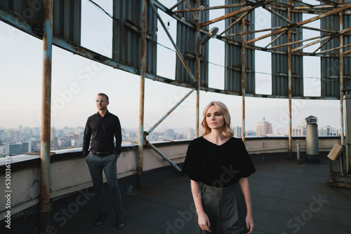 Romantic, young and happy caucasian couple in stylish clothes on the rooftop enjoying view and time together. Art portrait of beautiful woman and man. Love, relationships, romance, happiness concept.
