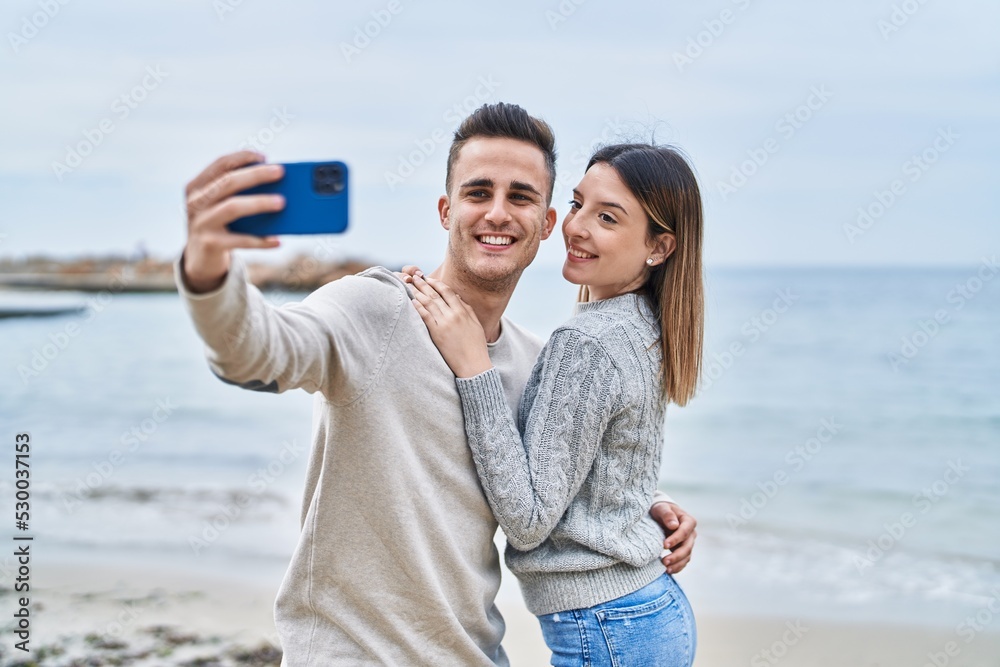 Man and woman couple hugging each other make selfie by smartphone at seaside