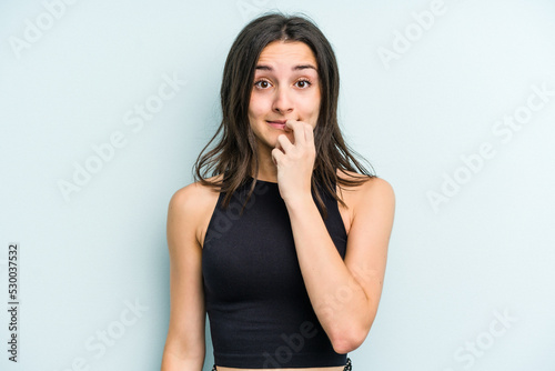 Young caucasian woman isolated on blue background biting fingernails, nervous and very anxious. © Asier