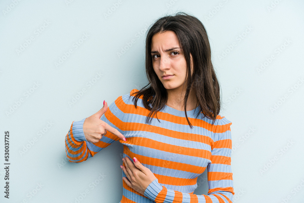 Young caucasian woman isolated on blue background having a liver pain, stomach ache. Young caucasian woman isolated on blue background having a liver pain, stomach ache.