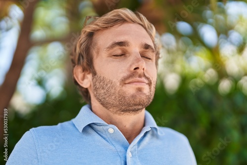 Young man smiling confident breathing at park