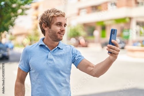 Young man smiling confident making selfie by the smartphone at street