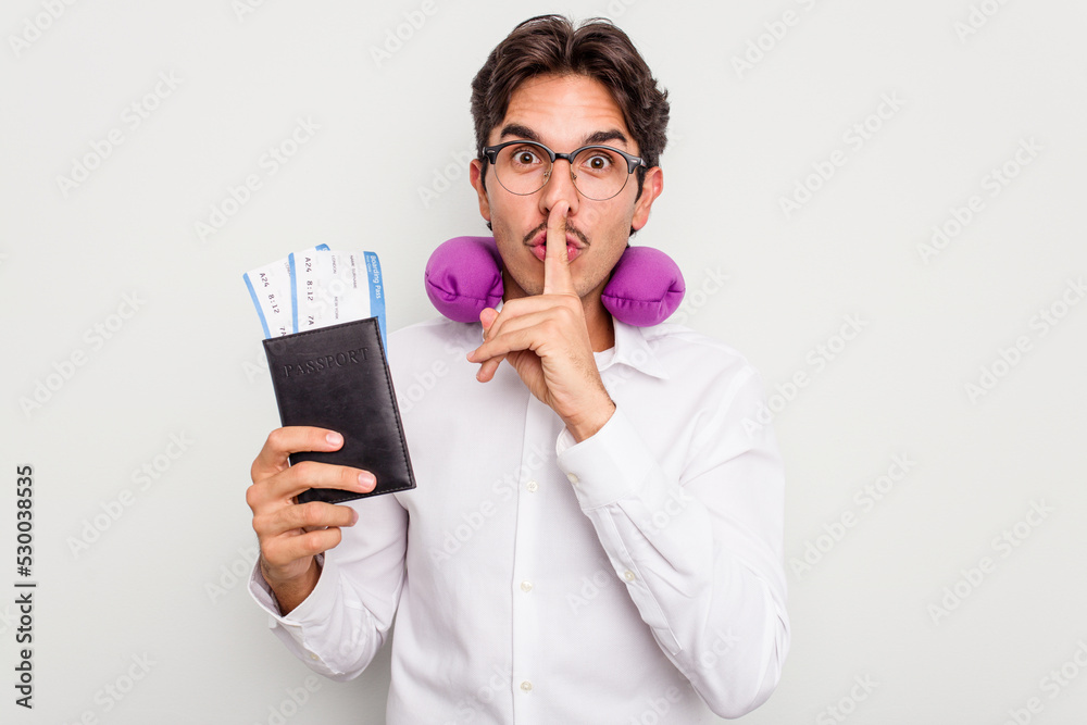 Young hispanic man with inflatable travel pillow holding passport isolated on white background keeping a secret or asking for silence. Young hispanic man with inflatable travel pillow holding passport isolated on white background keeping a secret or asking for silence.