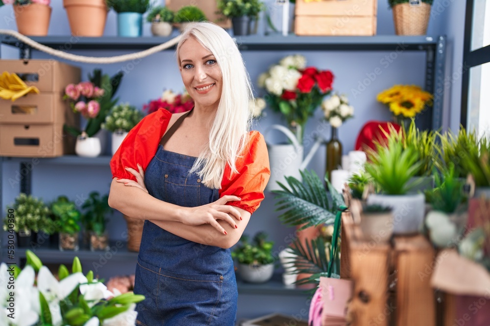 Young blonde woman florist smiling confident standing with arms crossed gesture at florist store