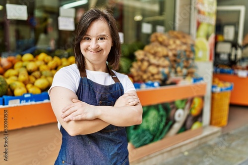 Fotografiet Young down syndrome woman smiling confident wearing apron at fruit store