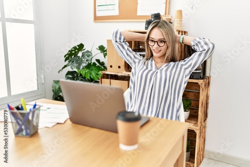 Young chinese woman smiling confident relaxed with hands on head at office