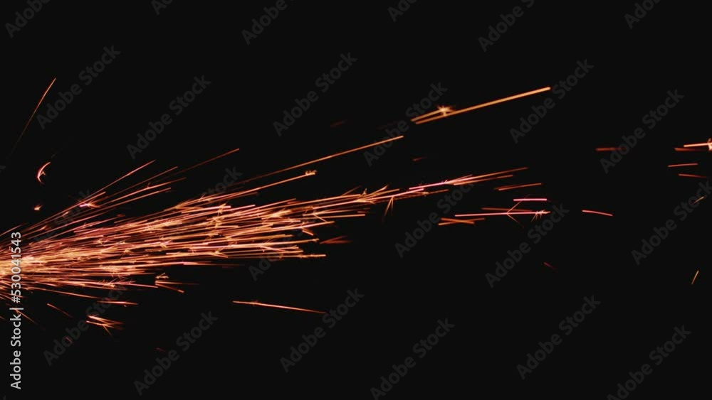 Sparks created by angle grinder flying on black background. Industrial production process details, close-up