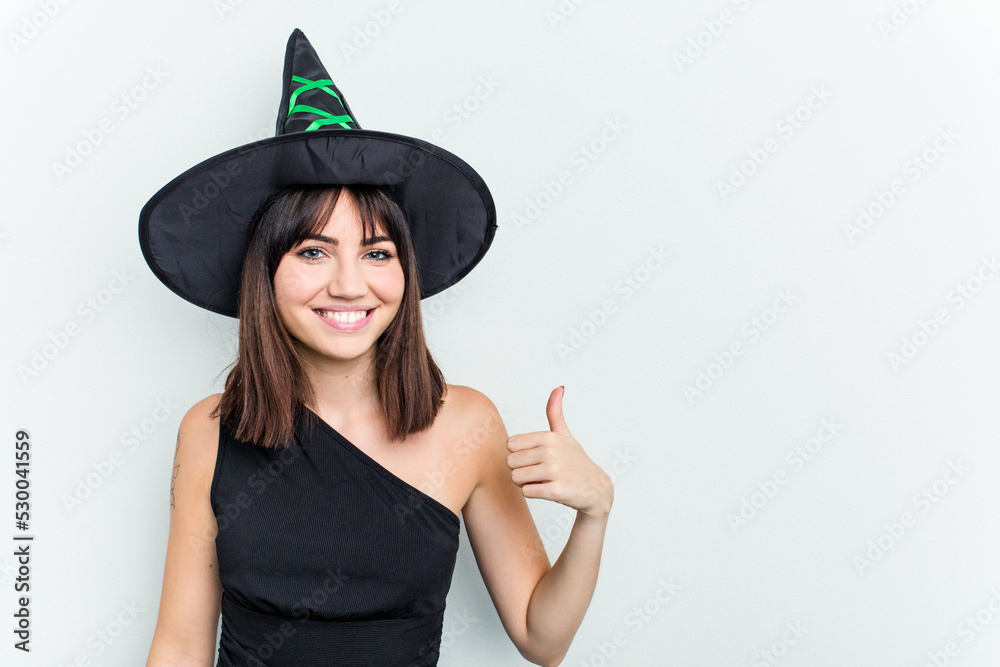 Young caucasian woman dressed as a witch isolated on white background smiling and raising thumb up Young caucasian woman dressed as a witch isolated on white background smiling and raising thumb up