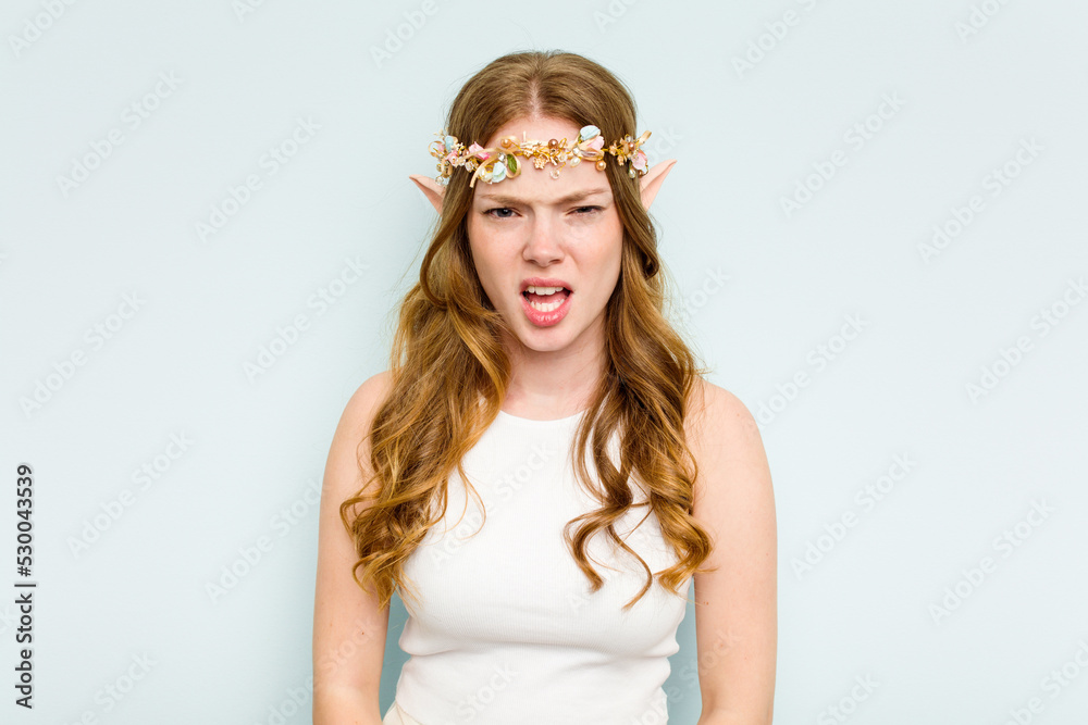 Young elf woman isolated on blue background screaming very angry and aggressive. Young elf woman isolated on blue background screaming very angry and aggressive.